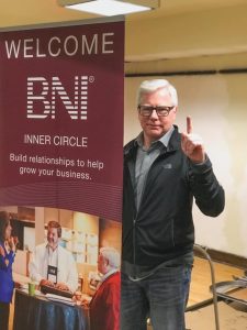 Interview-Attorney William J. McCabe. Criminal defense law. Image of Bill in a black sweater at a fundraising event with a BNI sign.