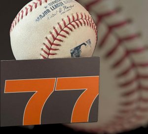 Crossing the Marketing Mendoza Line. An image of a white MLB baseball with the orange and gray 77 Design Co business card.